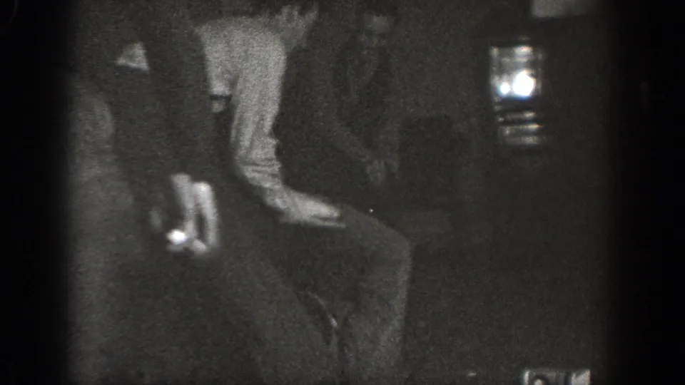 Several adult men in dark clothing appear clustered near the floor during a candid 1939 Chelan indoor home-movie moment.