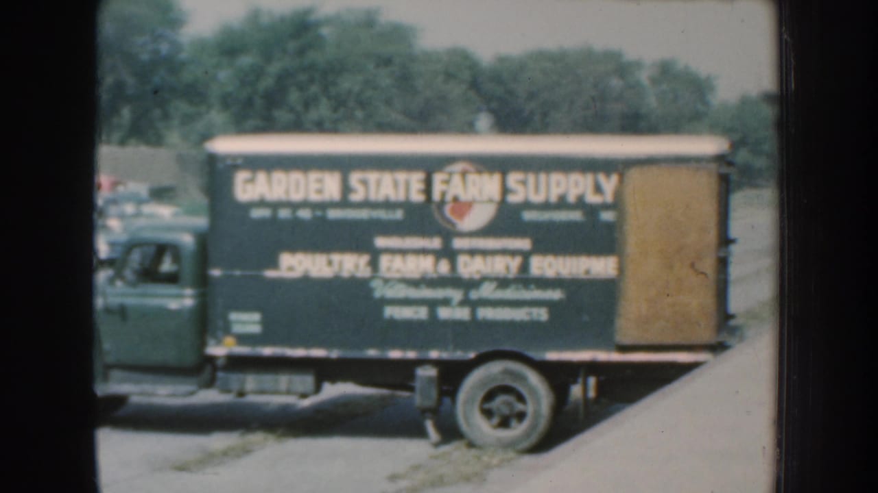 Green Garden State Farm Supply truck in 1959 Nebraska footage, with poultry, farm, and dairy equipment text visible on the side.