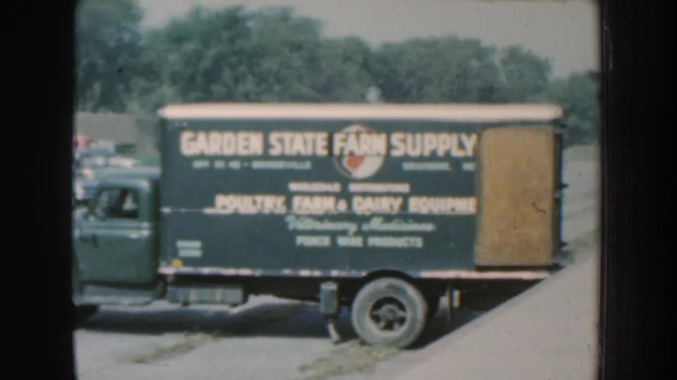 Green Garden State Farm Supply truck in 1959 Nebraska footage, with poultry, farm, and dairy equipment text visible on the side.