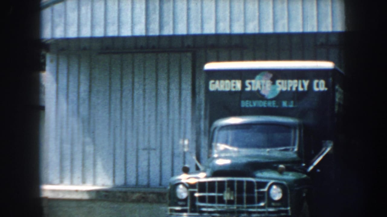 Vintage truck front and partial second truck seen through dark film-frame edges.