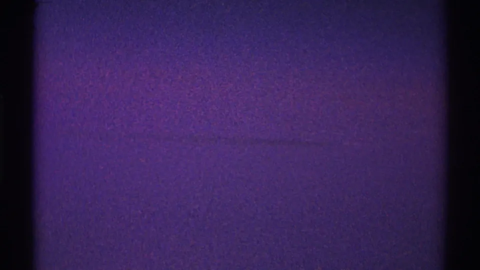 Final 8mm frame of the Los Angeles night sky, showing purple low-light grain, black gate edges, and faint streak-like marks.