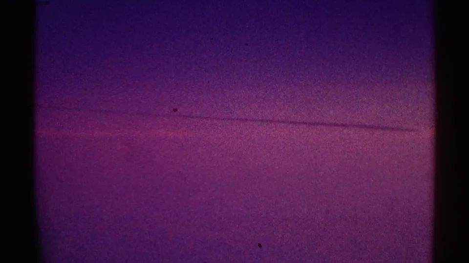 1969 Los Angeles 8mm frame with a faint line across the purple night sky and visible contact-sheet divider at left.
