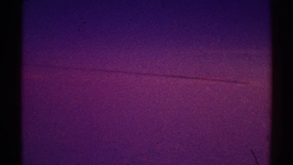 1969 Los Angeles 8mm frame with a faint horizontal line across the lower purple night sky and visible dust artifacts.