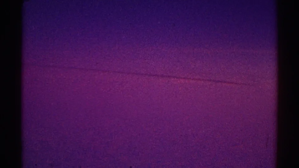 1969 Los Angeles 8mm frame showing a saturated purple-magenta sky field with a faint horizontal band and visible film grain.