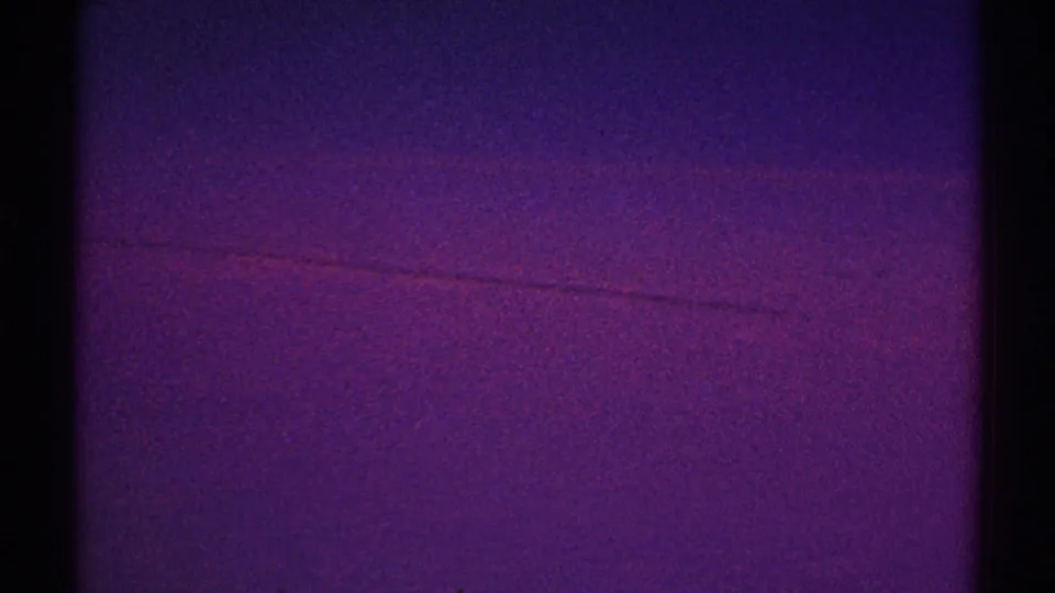 1969 Los Angeles 8mm still showing a darker purple sky band below a pink-violet gradient, with visible grain and gate edge.