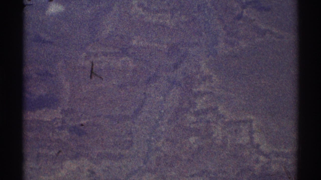 1969 Los Angeles-area 8mm aerial view with soft, purple-tinged terrain and heavy film grain.
