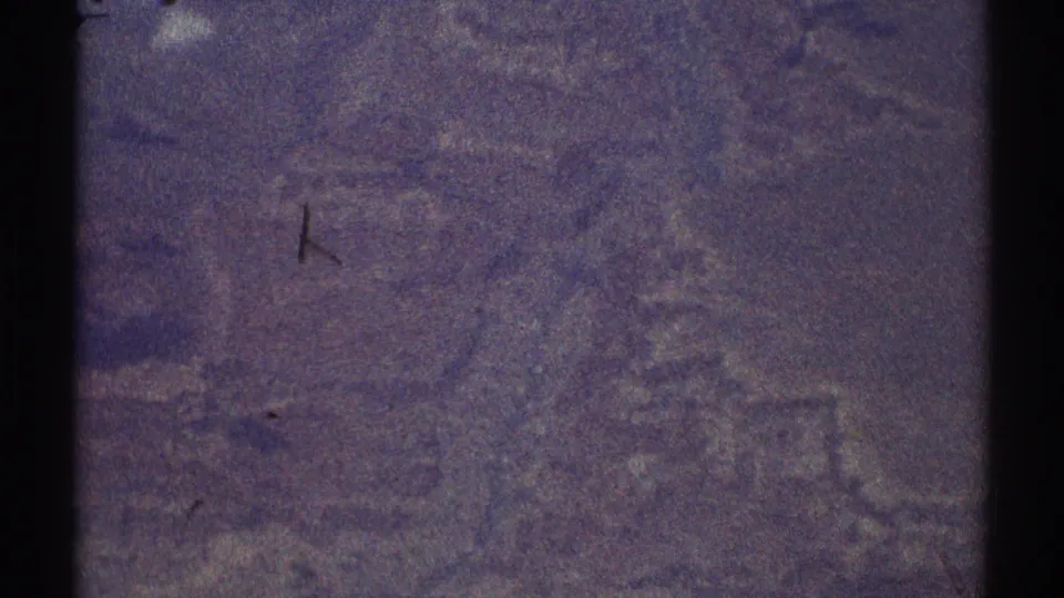 1969 Los Angeles-area 8mm aerial view with soft, purple-tinged terrain and heavy film grain.