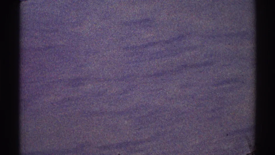 1969 8mm frame showing a dark aerial view through an aircraft window near the Los Angeles metadata location, with terrain details mostly indistinct.
