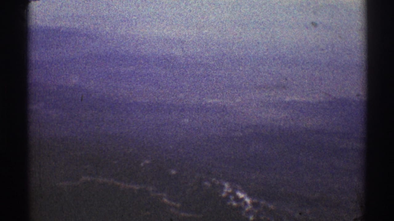 Hazy distant hills and a pale sky with dark 8mm film borders.
