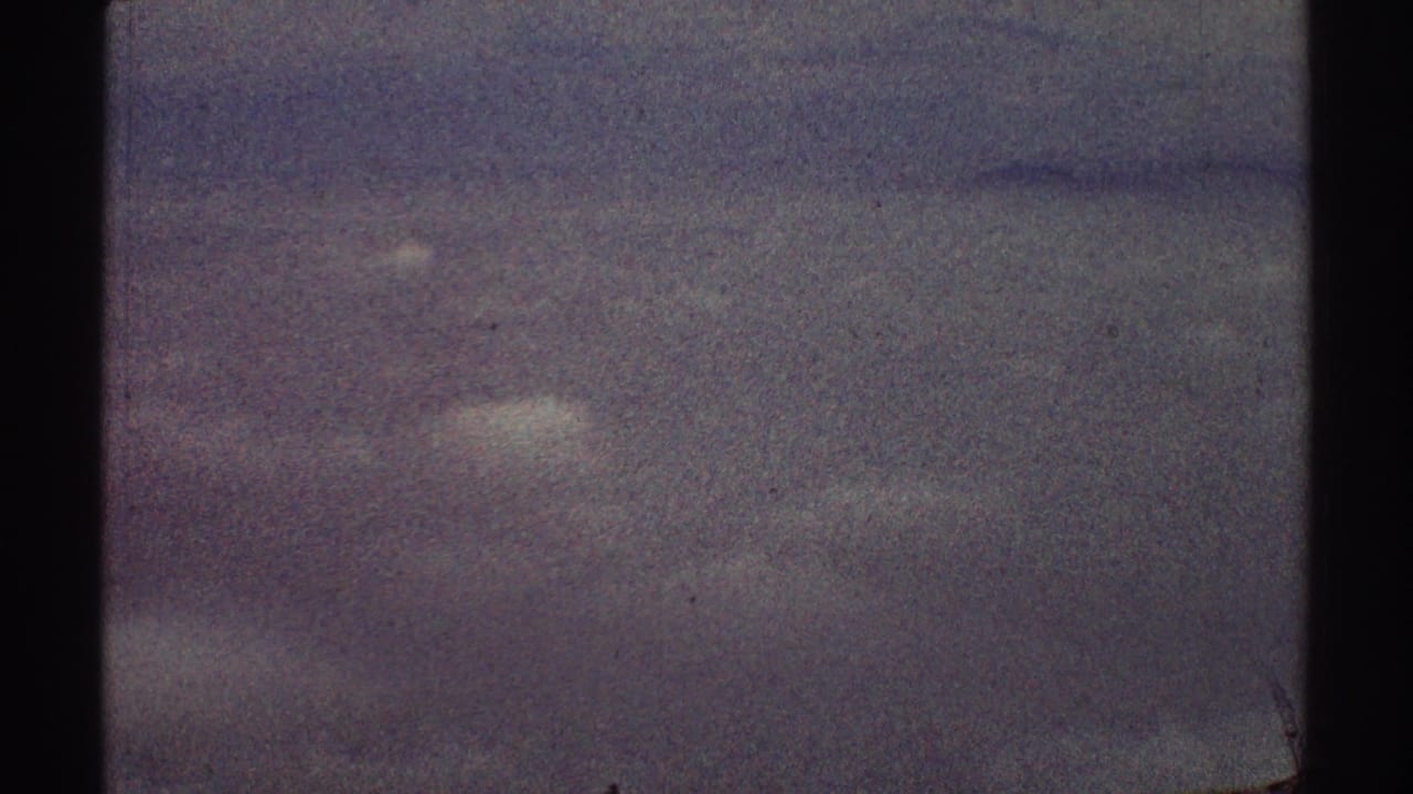 Hazy purple-gray sky seen through dark airplane window framing.