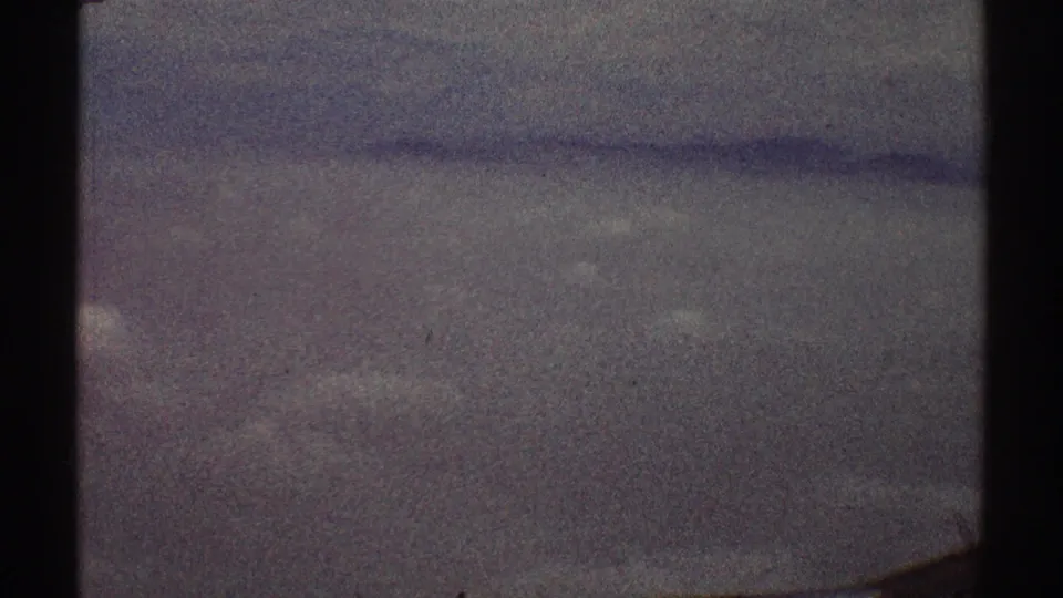 A soft, grainy airplane-window view of hazy sky, consistent with the Los Angeles aerial clip metadata.