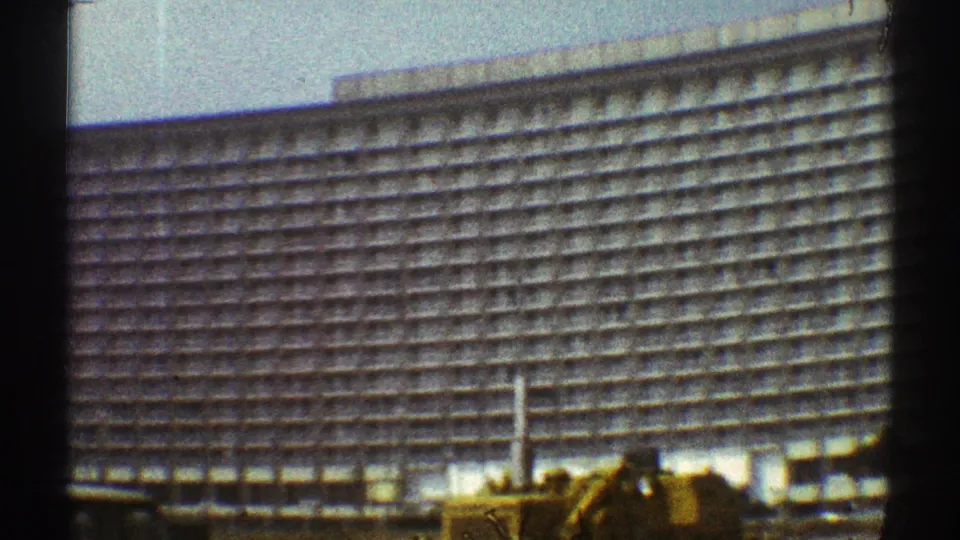 A slightly shifted 8mm view frames the Los Angeles high-rise facade, a vertical pole, and construction equipment at street level.