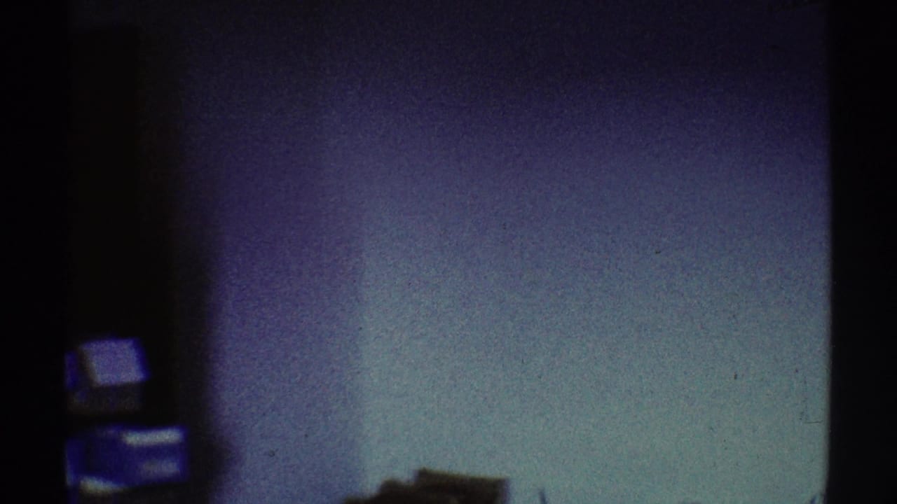 Dark interior edge with a pale wall and small stacked rectangular objects.