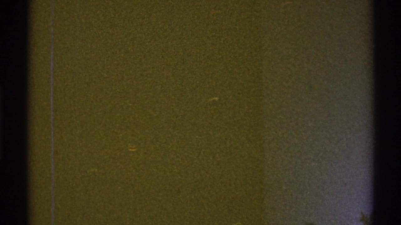Mostly flat brown wall with a dark vertical door frame and faint scratches.