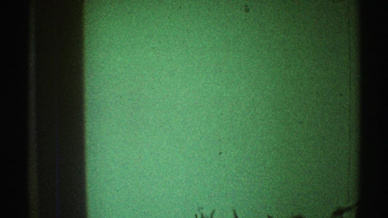 Green-tinted interior wall with dark vertical framing and faint marks near the lower edge.