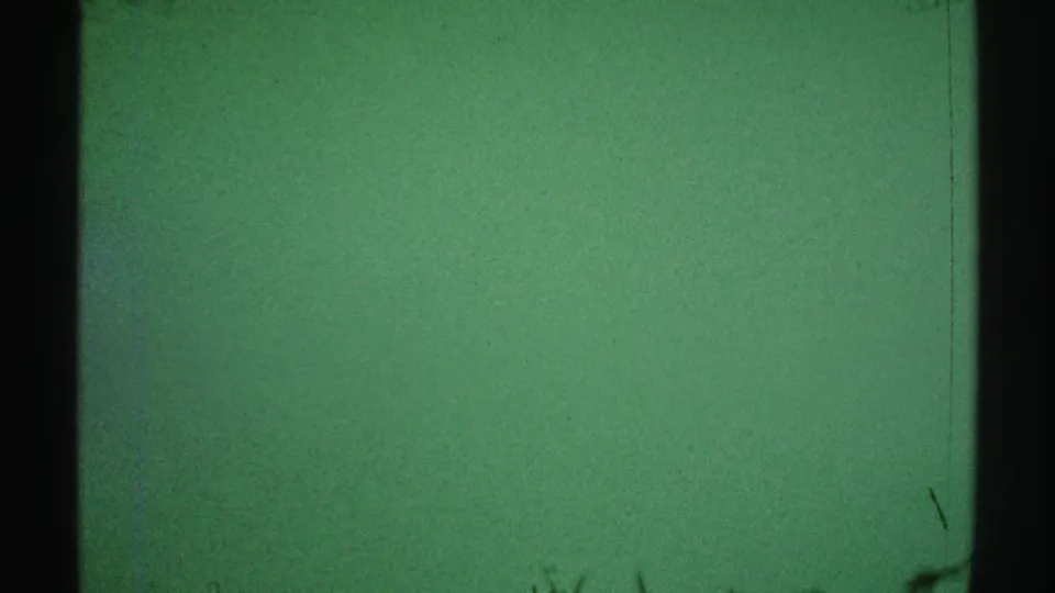 1969 Los Angeles 8mm frame showing a pale green interior wall, dark left edge, subtle scratches, and slight exposure unevenness.