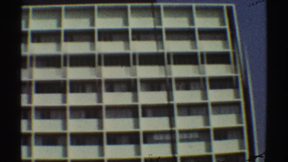 1969 Los Angeles home-movie frame showing the upper facade of a mid-century apartment building with balcony rows.