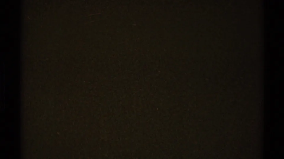 Dark 1969 8mm frame from Los Angeles metadata, showing grain, low exposure, and a black vertical film-edge band.