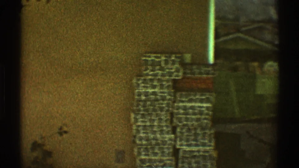1969 Los Angeles 8mm frame with a stucco wall, partial window, dark vertical edge, and block-like exterior feature.
