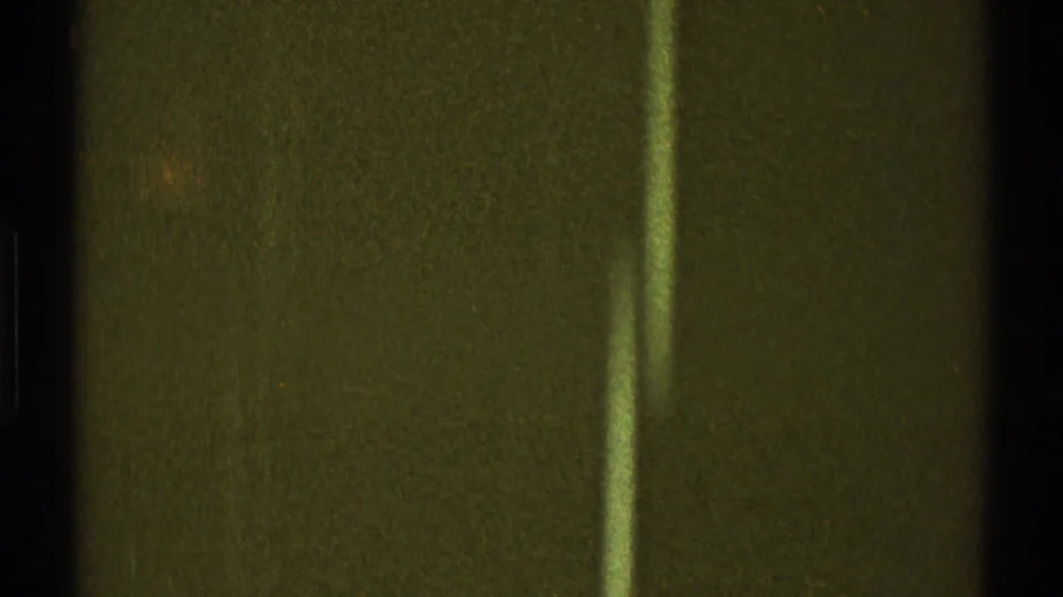 1969 Los Angeles 8mm frame showing a dark exterior wall surface with a pale vertical post in the foreground.
