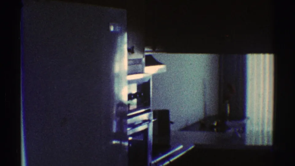 1969 Los Angeles home interior showing a small kitchen or dining area with shelving, a curtain, and household items.