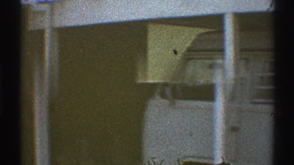 1969 Los Angeles home-movie frame of a residential wall with porch columns and recessed exterior details.
