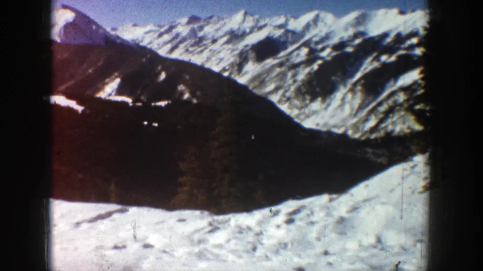 Mountain view near Aspen in 1961, showing snow-covered peaks, a dark ridge, and bright winter light.