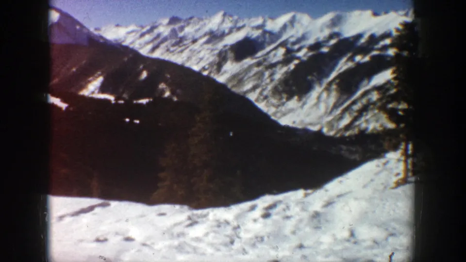1961 Aspen home-movie view of snowy mountain ridges, shaded terrain, and sunlit snow near the camera.