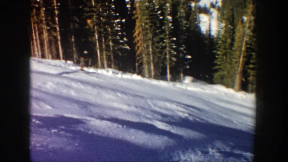 The skier has moved out of clear view, leaving the Aspen slope, trees, and winter shadows visible.