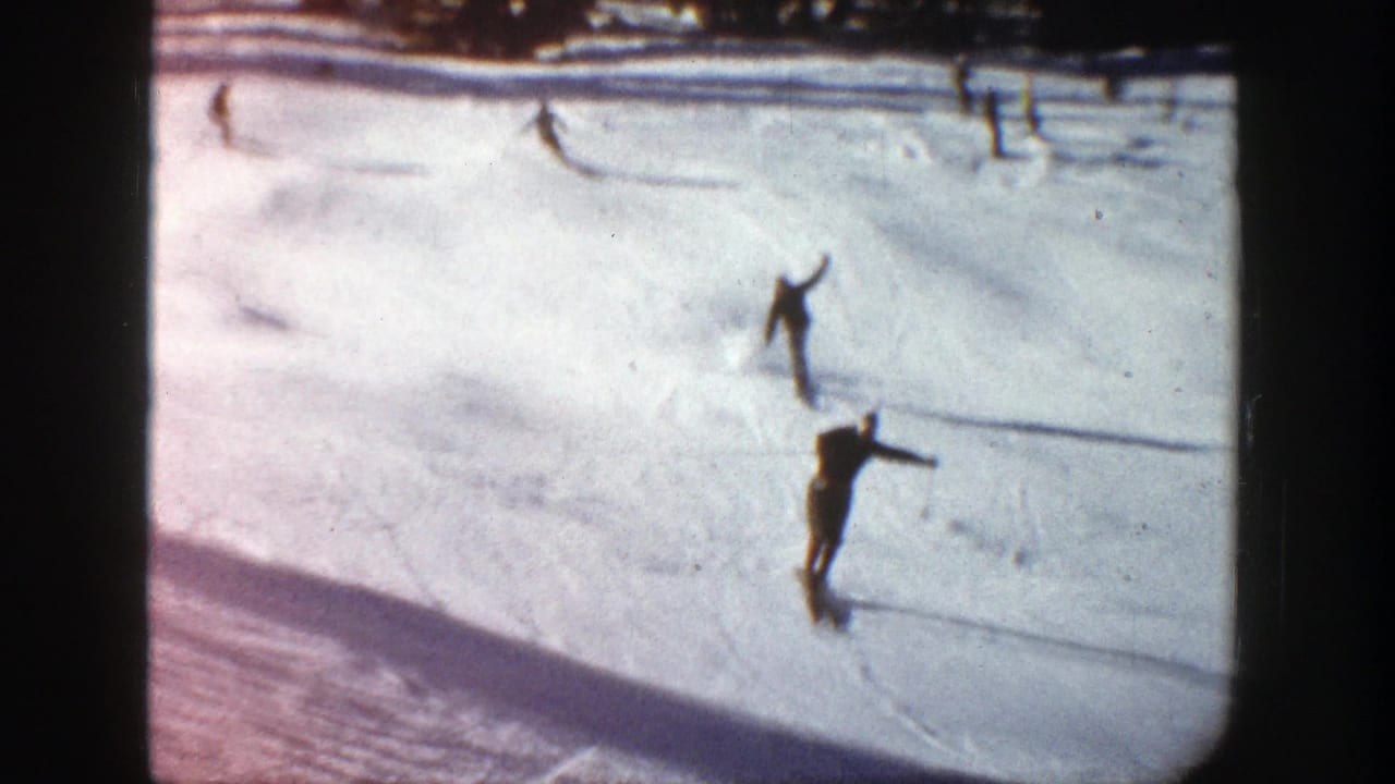 Several skiers cross a snowy hillside, with one figure nearer the camera.
