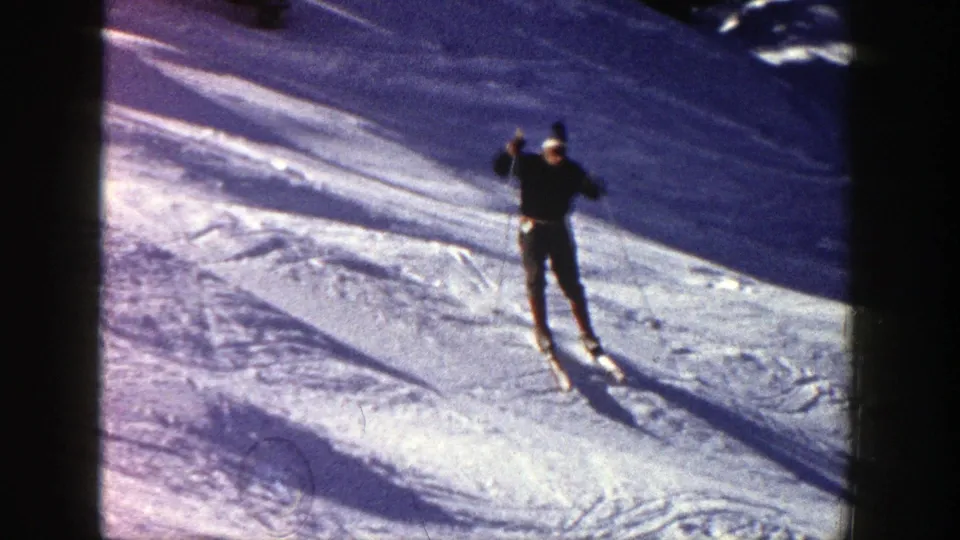 1961 Aspen frame showing a skier descending over uneven snow, framed by contact-sheet borders and winter light.