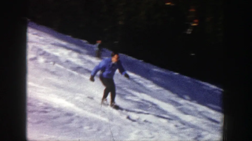 The skier continues downhill on the Aspen snow trail, with textured tracks and dark trees behind him.