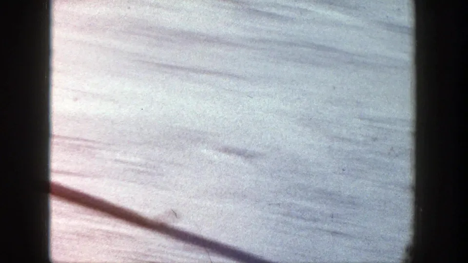 Late frame from the 1961 Aspen ski clip showing the snow-covered slope after the skier has moved out of view.