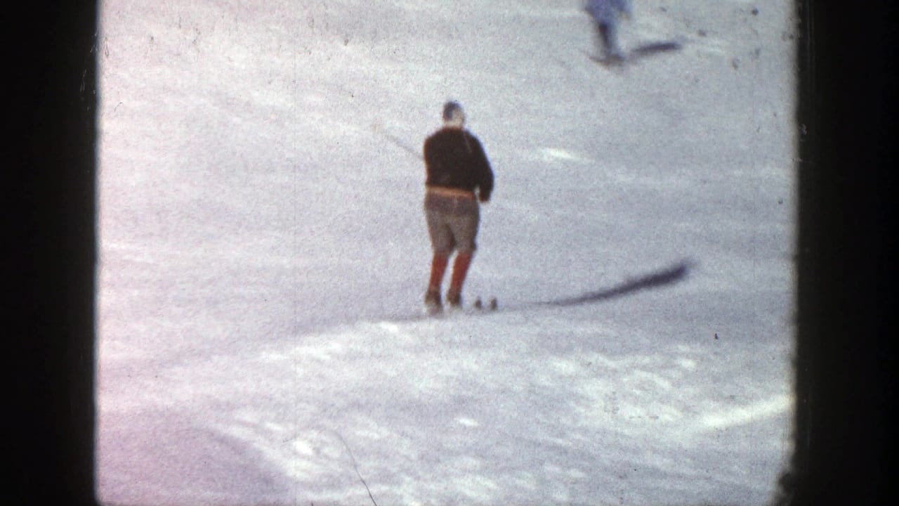 Skier moving away across a bright snow-covered slope.