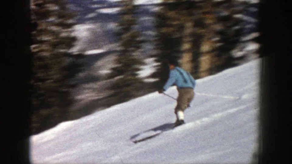 A rear view shows the skier continuing downhill on the snowy Aspen slope, with dense evergreens beyond the run.