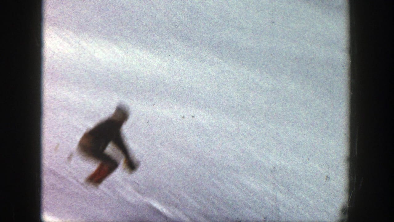 Skier crouches in midair above a pale snowy slope.