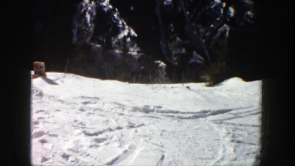 Distant skier moves across an Aspen, Colorado snow slope in 1961 home-movie footage.