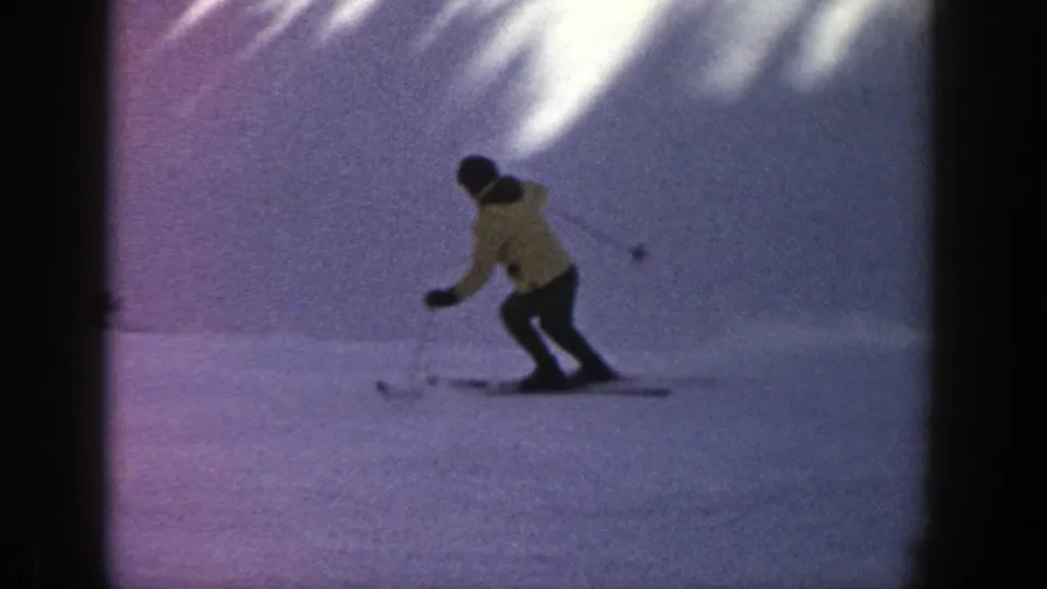 In Aspen, Colorado, 1961, a skier in a yellow jacket moves downhill across snow in soft 8mm color.