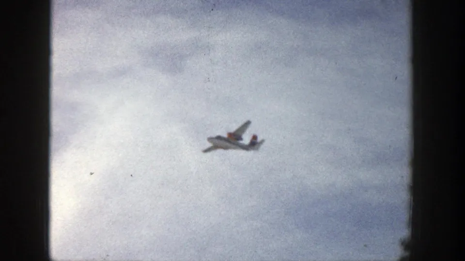 The small plane appears closer and clearer against bright clouds in the Aspen, Colorado home-movie footage from 1961.