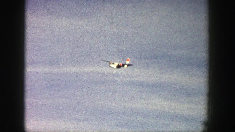Near the end of the clip, the red and white plane remains visible against the Aspen sky in softly faded 8mm color.