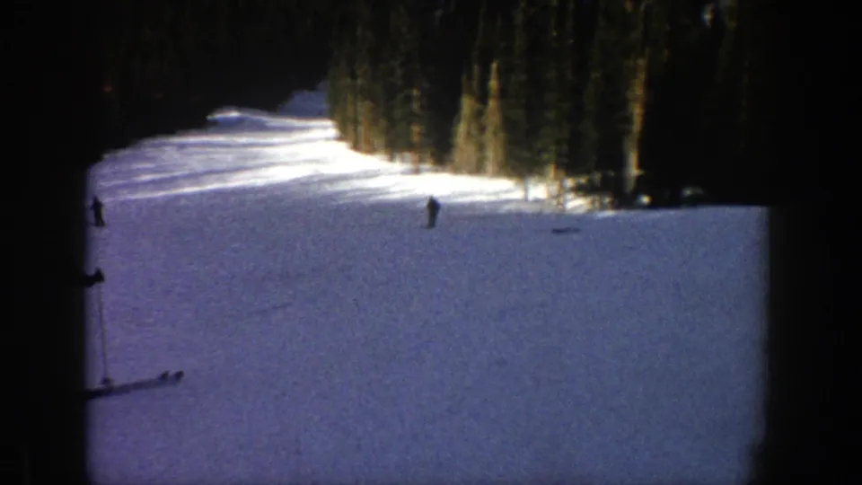 A broad 1961 Aspen ski trail appears in partial shade, with small skiers moving across the snow near the forest edge.
