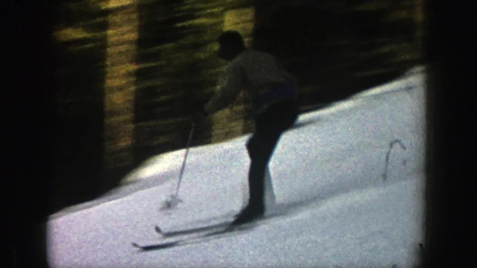 The skier continues across the Aspen snowfield, partially blurred by fast motion and the 8mm home-movie camera.