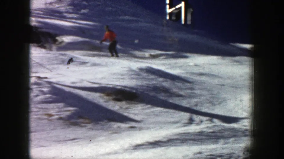 Red-jacketed skier crosses a snow-covered Aspen resort slope in this 1961 8mm home-movie frame.