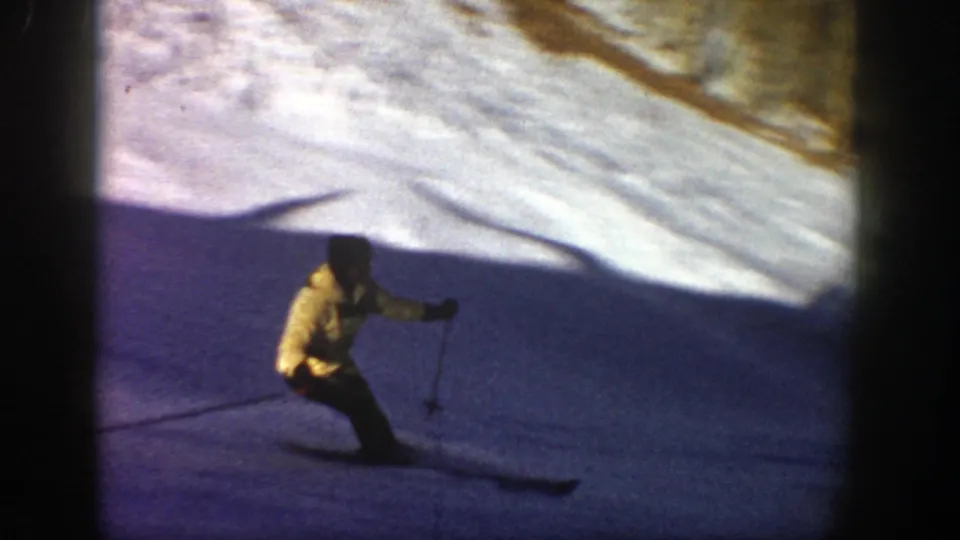 A skier in a yellow jacket and dark pants turns across the snow in Aspen, Colorado, with rounded 8mm frame edges visible.