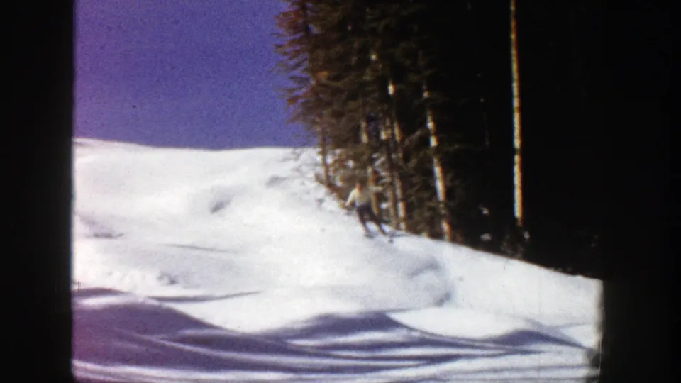 The frame holds on the Aspen snowfield and dense evergreen edge, emphasizing terrain and winter light.