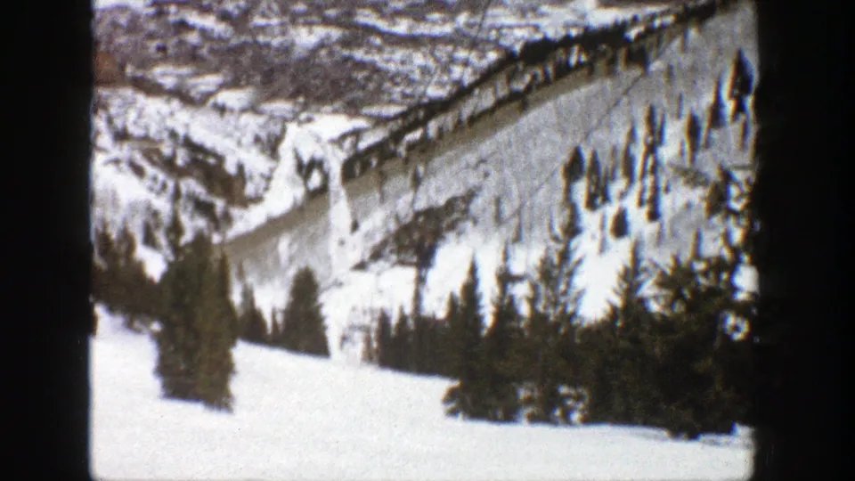Aspen, Colorado winter resort view from 1961, with open snowfields, evergreens, and lift infrastructure on the mountainside.