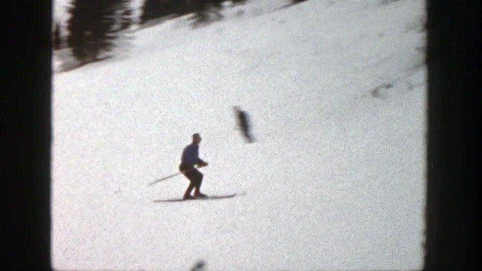 A skier crosses the bright Aspen snowfield, seen through soft 8mm focus and high snow exposure.