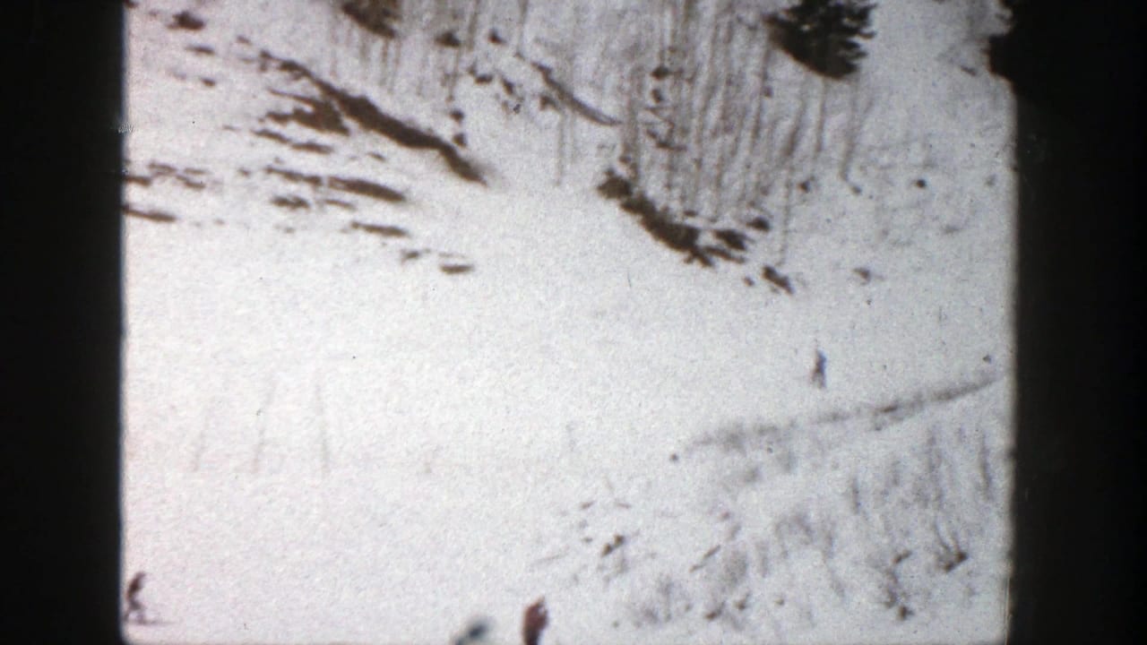 1961 Aspen, Colorado 8mm frame showing a bright snowy slope with small skiers and evergreen trees in soft focus.