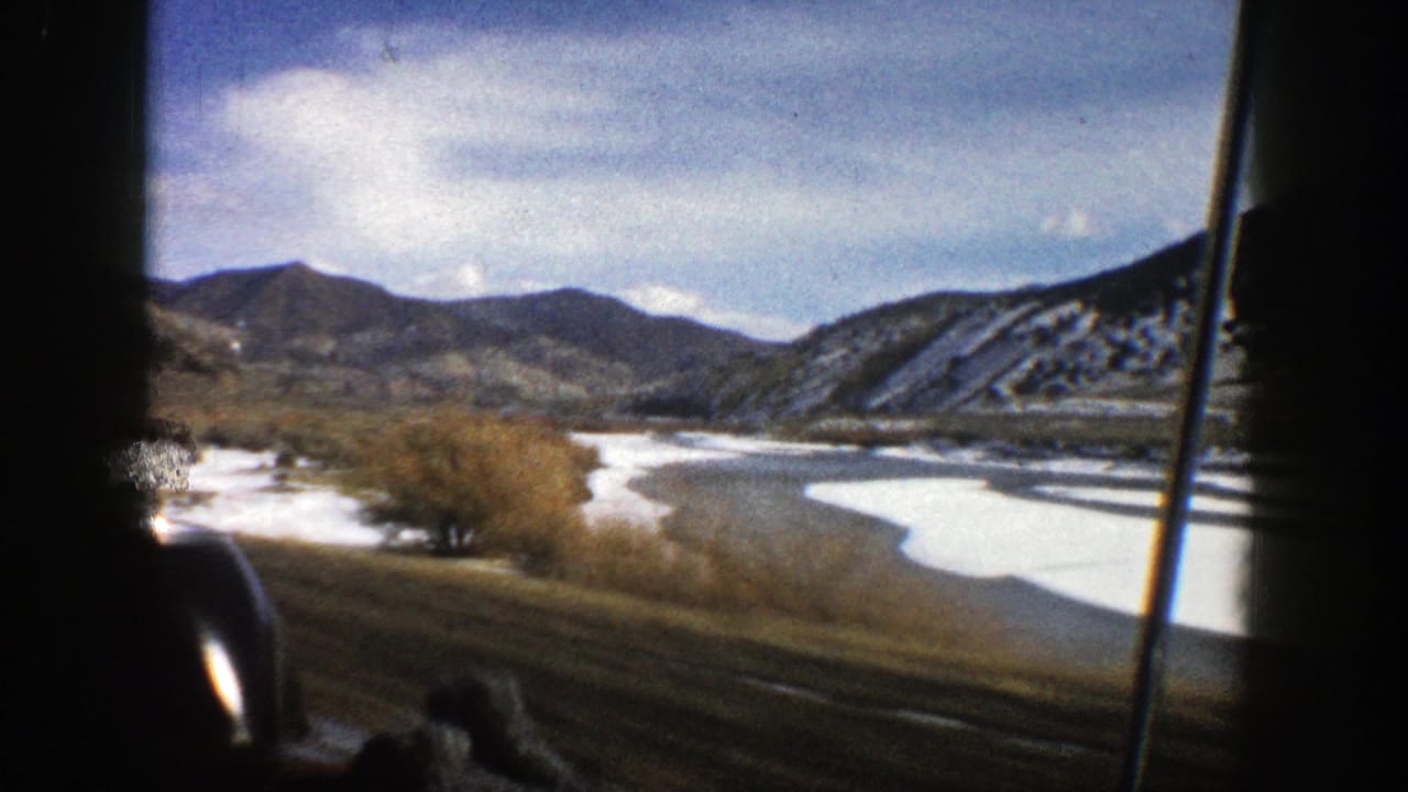 1961 Aspen, Colorado 8mm frame showing a snowy valley and winding waterway filmed through a moving car window.