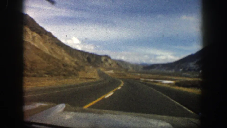 End frame of 1961 Aspen, Colorado road-trip footage, filmed from inside a car on a winding mountain highway.